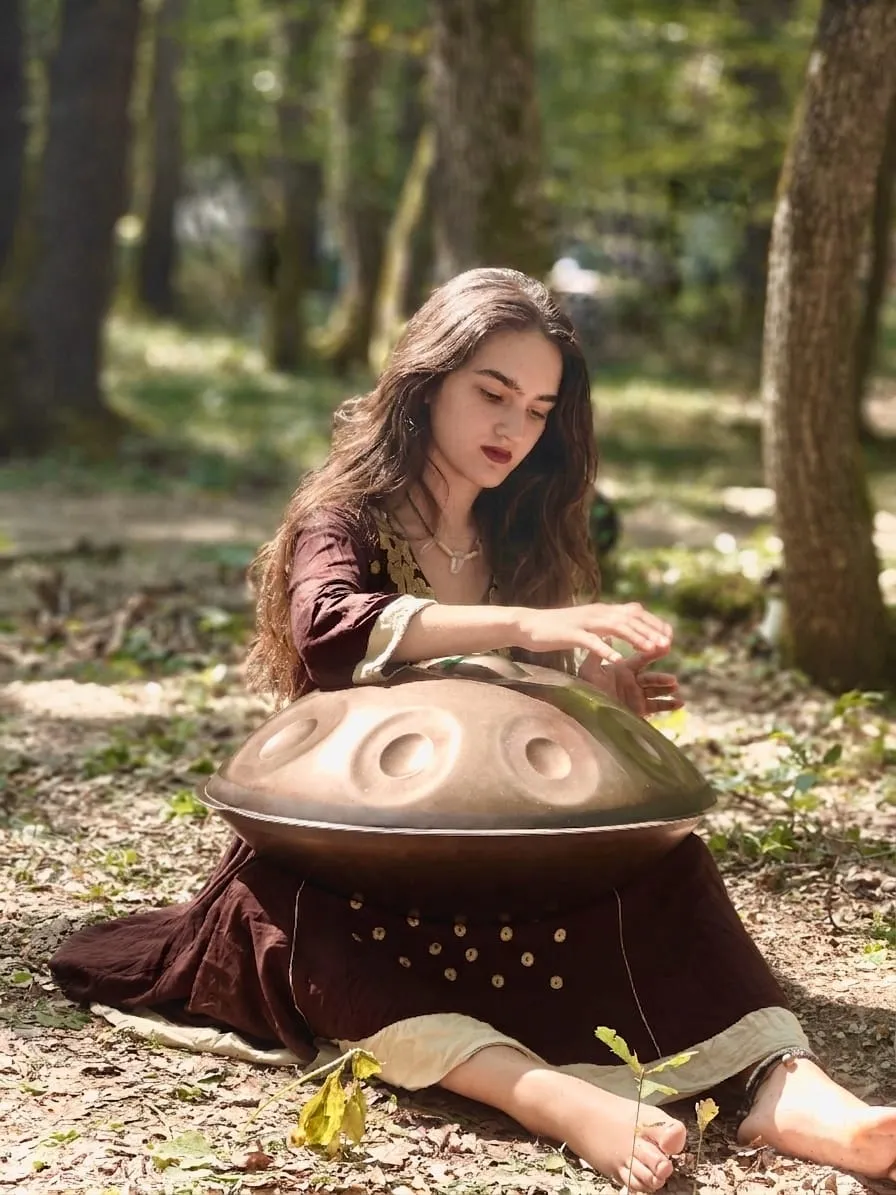 Vanessa cântând la un handpan într-o poiană din pădurea de lângă Cluj-Napoca